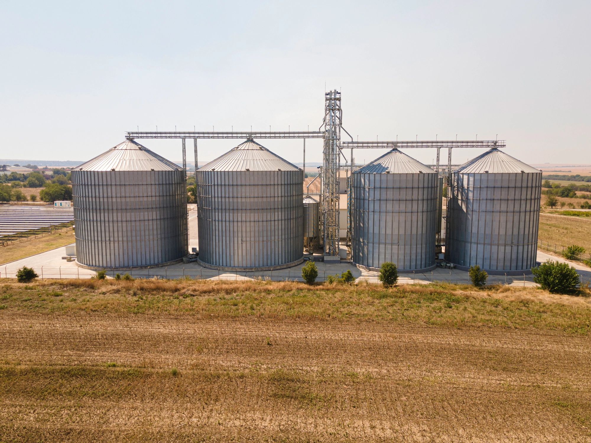 Agricultural silos in a field, representing grain storage and supply reliability